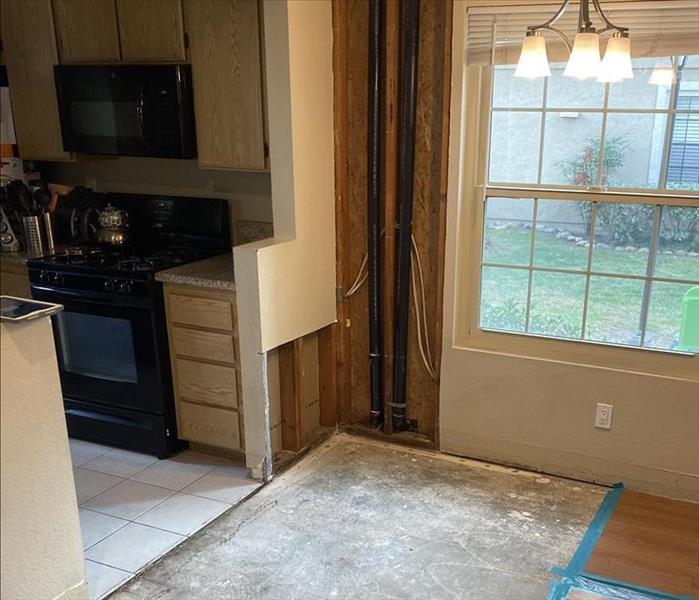A photo of a condo with missing flooring and drywall.