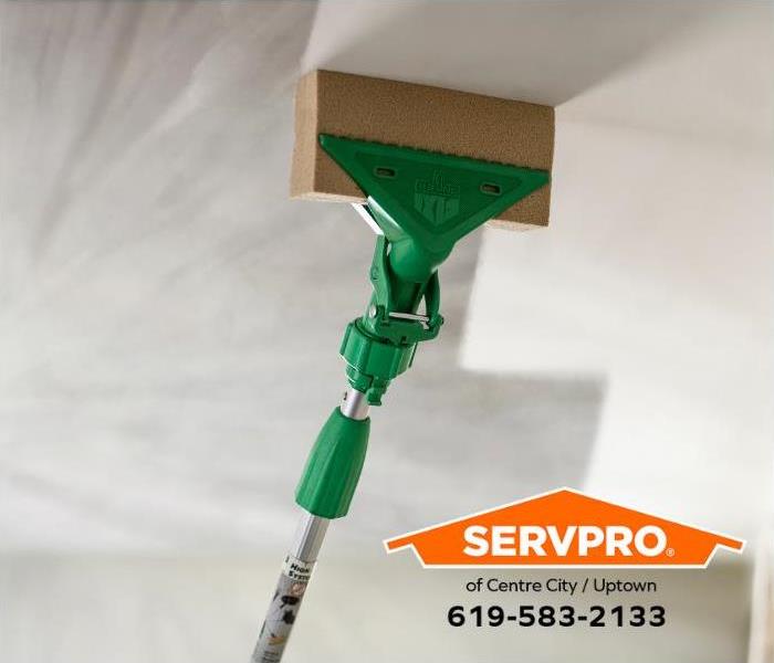 SERVPRO Professionals clean soot and smoke off a ceiling. 