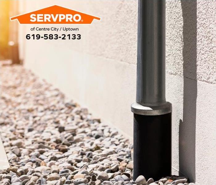 A downspout feeds directly into a French drain to catch stormwater runoff.