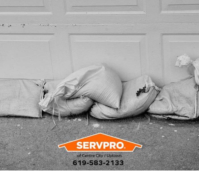 Sandbags are placed in front of a garage door to prevent water intrusion.